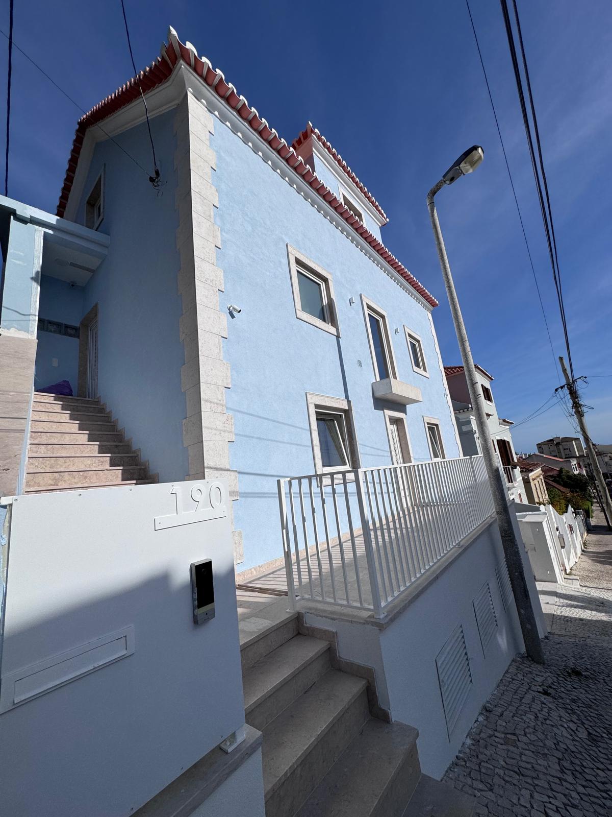 Obra real Multigesso — fachada de moradia em Lisboa com reboco e pintura azul